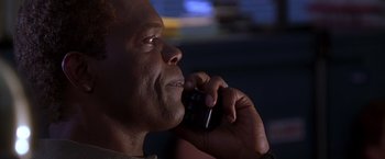 Movie still from “The Negotiator” (1998), directed by F. Gary Gray – A person talking on a cell phone; Close Up shot, Low angle