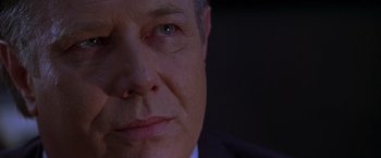 Movie still from “The Negotiator” (1998), directed by F. Gary Gray – A man's face in a suit and tie; Close Up shot, Over the shoulder angle
