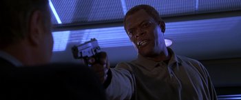 Movie still from “The Negotiator” (1998), directed by F. Gary Gray – A man holding a gun in his right hand; Close Up shot, Low angle