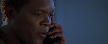 Movie still from “The Negotiator” (1998), directed by F. Gary Gray – A person talking on a cell phone; Close Up shot, Low angle