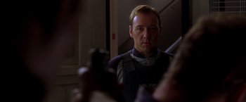 Movie still from “The Negotiator” (1998), directed by F. Gary Gray – A man in a police uniform looking at the camera; Close Up shot, Over the shoulder angle