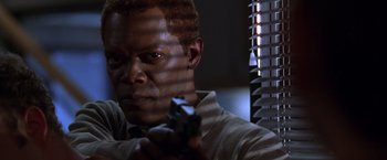 Movie still from “The Negotiator” (1998), directed by F. Gary Gray – A person holding a gun in a room; Close Up shot, Low angle