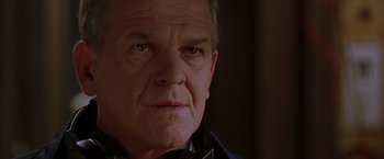 Movie still from “The Negotiator” (1998), directed by F. Gary Gray – An older man is looking into the camera; Close Up shot, Low angle