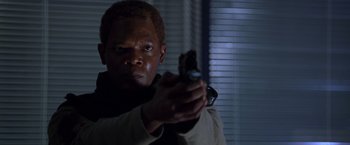 Movie still from “The Negotiator” (1998), directed by F. Gary Gray – A man is holding a gun in a room; Close Up shot, Low angle
