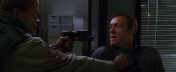 Movie still from “The Negotiator” (1998), directed by F. Gary Gray – A man holding a gun pointed at another man's face; Close Up shot, Over the shoulder angle