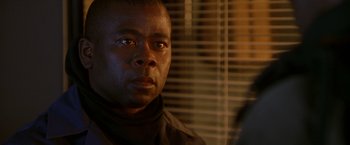 Movie still from “The Negotiator” (1998), directed by F. Gary Gray – A person looking at the camera; Close Up shot, Over the shoulder angle