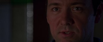 Movie still from “The Negotiator” (1998), directed by F. Gary Gray – A man's face with a dark background; Extreme Close Up shot, Low angle
