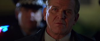 Movie still from “The Negotiator” (1998), directed by F. Gary Gray – An older man wearing a suit and tie looking at the camera; Close Up shot, Low angle