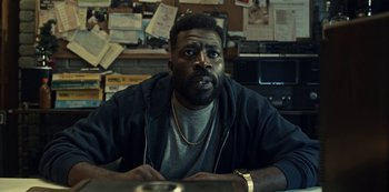 Movie still from “Guillermo del Toro's Cabinet of Curiosities” (2022), directed by Keith Thomas – A man sitting at a table in front of papers; Close Up shot, Low angle