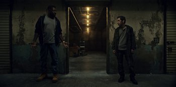 Movie still from “Guillermo del Toro's Cabinet of Curiosities” (2022), directed by Keith Thomas – Two men are standing in an empty building; Wide shot, High angle