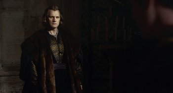 Movie still from “The Other Boleyn Girl” (2008), directed by Justin Chadwick – A man standing in front of candles in a dark room; Medium shot, Low angle