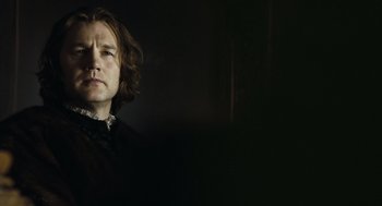 Movie still from “The Other Boleyn Girl” (2008), directed by Justin Chadwick – A man with long brown hair wearing a black shirt; Close Up shot, Low angle