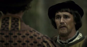 Movie still from “The Other Boleyn Girl” (2008), directed by Justin Chadwick – A man with a beard wearing a hat and looking at another man with a beard; Close Up shot, Over the shoulder angle