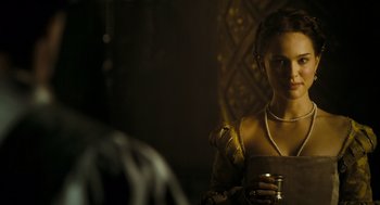 Movie still from “The Other Boleyn Girl” (2008), directed by Justin Chadwick – A woman holding a glass of wine in a dark room; Close Up shot, Over the shoulder angle
