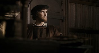 Movie still from “The Other Boleyn Girl” (2008), directed by Justin Chadwick – A man with a beard wearing a hat and looking into a mirror; Medium shot, Over the shoulder angle