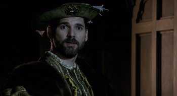 Movie still from “The Other Boleyn Girl” (2008), directed by Justin Chadwick – A man wearing a hat with feathers on top of his head; Close Up shot, Over the shoulder angle