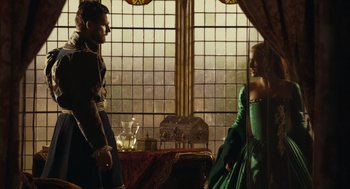 Movie still from “The Other Boleyn Girl” (2008), directed by Justin Chadwick – A man and a woman dressed in medieval garb in front of stained glass windows; Medium shot, Over the shoulder angle