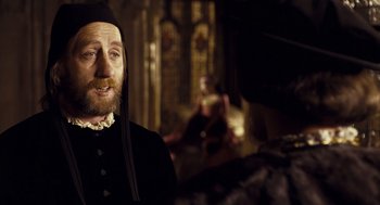 Movie still from “The Other Boleyn Girl” (2008), directed by Justin Chadwick – A man with a long beard wearing a black hat; Medium shot, Over the shoulder angle