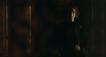 Movie still from “The Other Boleyn Girl” (2008), directed by Justin Chadwick – A woman standing in a dark room wearing a black outfit; Medium shot, Over the shoulder angle