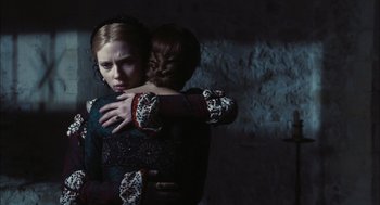 Movie still from “The Other Boleyn Girl” (2008), directed by Justin Chadwick – A woman hugging another woman in front of a brick wall; Medium shot, Low angle