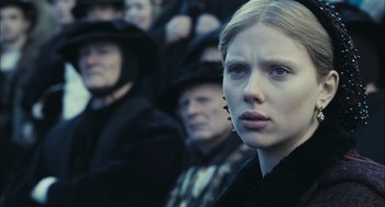 Movie still from “The Other Boleyn Girl” (2008), directed by Justin Chadwick – A woman in a crowd of people wearing black clothes; Close Up shot, Over the shoulder angle