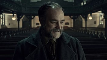 Movie still from “Guillermo del Toro's Cabinet of Curiosities” (2022), directed by Keith Thomas – An older man with a goatee is smiling for the camera; Close Up shot, Low angle