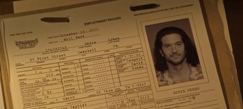 Movie still from “Guillermo del Toro's Cabinet of Curiosities” (2022), directed by Keith Thomas – An employment record is shown with a picture of a man; Extreme Close Up shot, Overhead angle