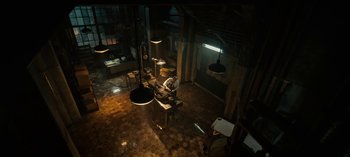 Movie still from “Guillermo del Toro's Cabinet of Curiosities” (2022), directed by Keith Thomas – An overhead view of a room with a person sitting at a desk; Extreme Wide shot, High angle