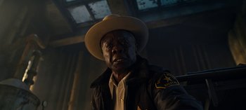 Movie still from “Guillermo del Toro's Cabinet of Curiosities” (2022), directed by Keith Thomas – A man wearing a cowboy hat and a jacket; Close Up shot, Low angle