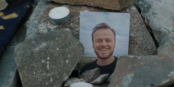 Movie still from “The Ritual” (2017), directed by David Bruckner – A picture of a man sitting on some rocks; Extreme Close Up shot, High angle