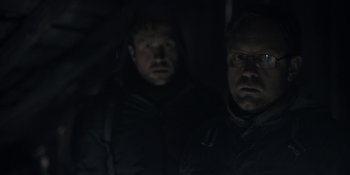 Movie still from “The Ritual” (2017), directed by David Bruckner – Two men in the dark looking at the camera; Close Up shot, Low angle