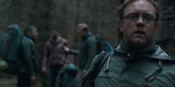 Movie still from “The Ritual” (2017), directed by David Bruckner – A group of people walking in the woods with backpacks; Close Up shot, Over the shoulder angle