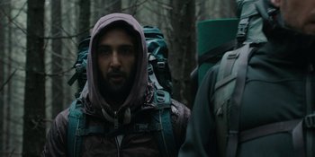 Movie still from “The Ritual” (2017), directed by David Bruckner – A man in a hooded jacket with a backpack in the woods; Medium shot, Low angle