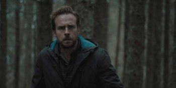 Movie still from “The Ritual” (2017), directed by David Bruckner – A man standing in the woods wearing a black jacket; Close Up shot, Over the shoulder angle