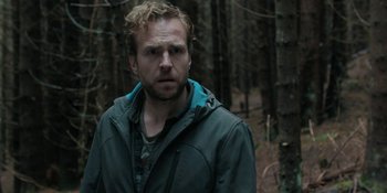 Movie still from “The Ritual” (2017), directed by David Bruckner – A man standing in the middle of a forest; Close Up shot, Over the shoulder angle