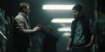 Movie still from “The Ritual” (2017), directed by David Bruckner – A group of people standing around in a room; Medium shot, Over the shoulder angle