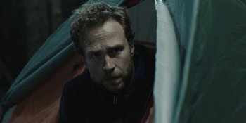 Movie still from “The Ritual” (2017), directed by David Bruckner – A person in a tent; Close Up shot, Low angle