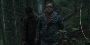 Movie still from “The Ritual” (2017), directed by David Bruckner – Two men walking through the woods in the rain; Medium shot, Low angle