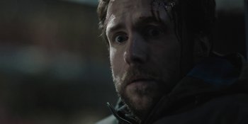 Movie still from “The Ritual” (2017), directed by David Bruckner – A person wearing a jacket with blood all over his face; Close Up shot, Over the shoulder angle