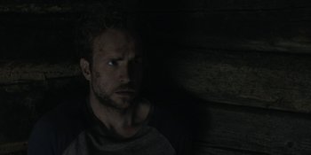 Movie still from “The Ritual” (2017), directed by David Bruckner – A person in a dark room; Close Up shot, Over the shoulder angle