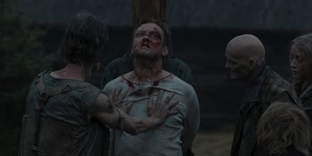 Movie still from “The Ritual” (2017), directed by David Bruckner – A man with blood all over his face is being held up; Medium shot, Over the shoulder angle