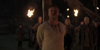 Movie still from “The Ritual” (2017), directed by David Bruckner – A group of people standing next to each other holding torches; Medium shot, Low angle