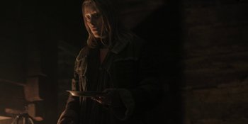 Movie still from “The Ritual” (2017), directed by David Bruckner – A woman holding a tablet in a dark room; Medium shot, Over the shoulder angle