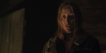 Movie still from “The Ritual” (2017), directed by David Bruckner – A woman with long blonde hair is looking at the camera; Close Up shot, Low angle