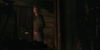 Movie still from “The Ritual” (2017), directed by David Bruckner – A man standing next to a wooden wall; Medium shot, Over the shoulder angle