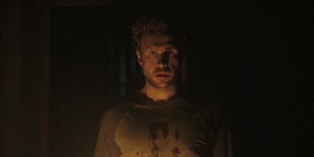 Movie still from “The Ritual” (2017), directed by David Bruckner – A man in a dark room with his mouth wide open; Close Up shot, Low angle