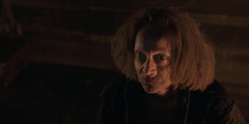 Movie still from “The Ritual” (2017), directed by David Bruckner – An older woman with a strange look on her face; Close Up shot, Low angle