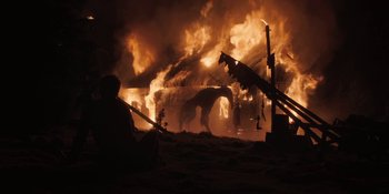 Movie still from “The Ritual” (2017), directed by David Bruckner – A man standing in front of a burning building; Wide shot, Low angle