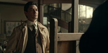 Movie still from “Guillermo del Toro's Cabinet of Curiosities” (2022), directed by Keith Thomas – A man wearing a suit and tie standing in a room; Medium shot, Low angle