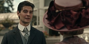 Movie still from “Guillermo del Toro's Cabinet of Curiosities” (2022), directed by Keith Thomas – A man wearing a suit and tie talking to a woman wearing a hat; Close Up shot, Over the shoulder angle